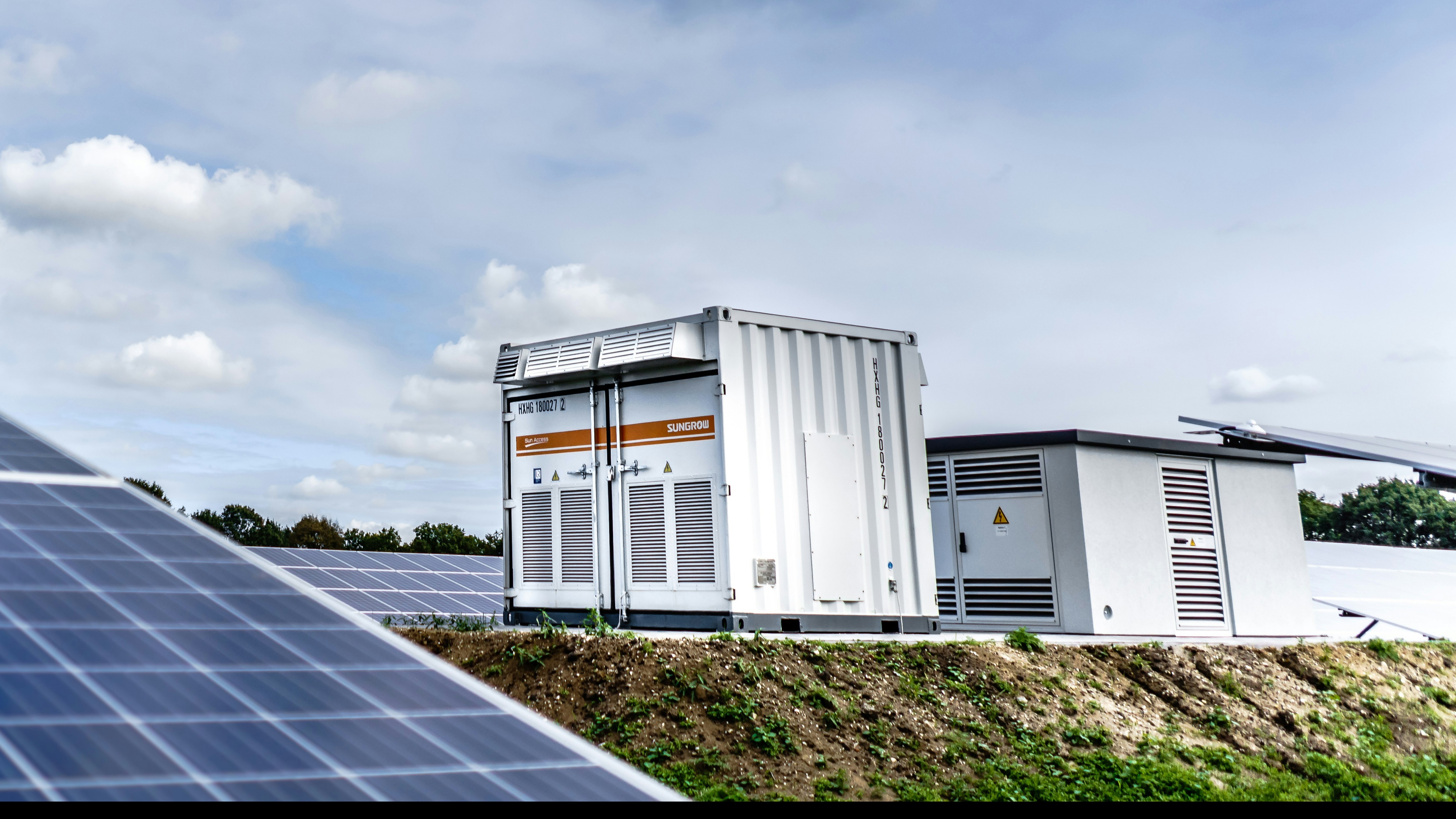 Illustrative containerized battery energy storage beside solar panels; official Celvonix photography pending